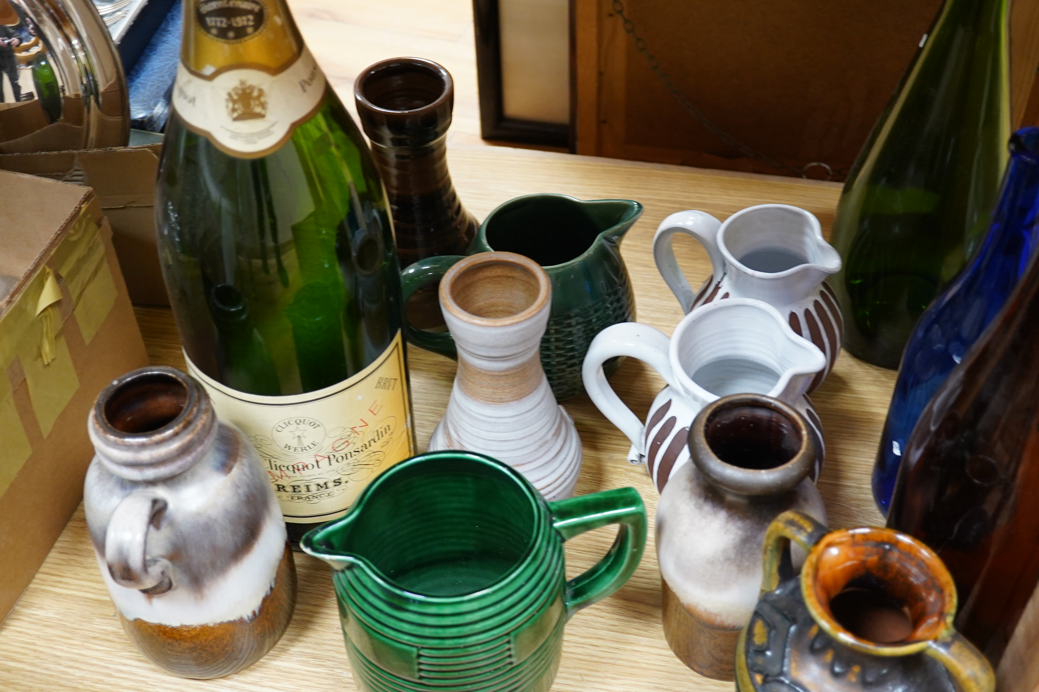 A collection of studio pottery and four glass bottles to include an oversized advertising bottle of Veuve Clicquot Ponsardin - 55cm high. Condition - fair to good